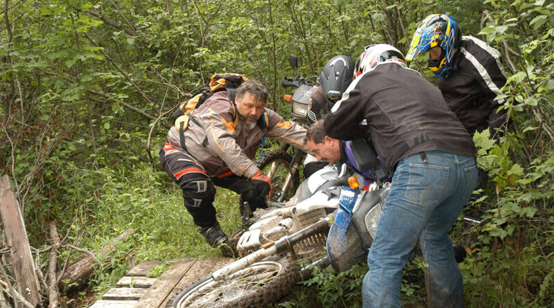 AMA Volunteer of the Year John Newton helping to pick up a motorcycle in the woods with a group of people